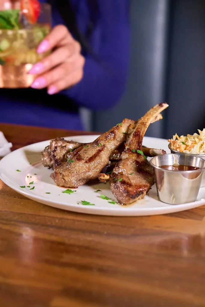 Lamb chops with sides on a white plate.