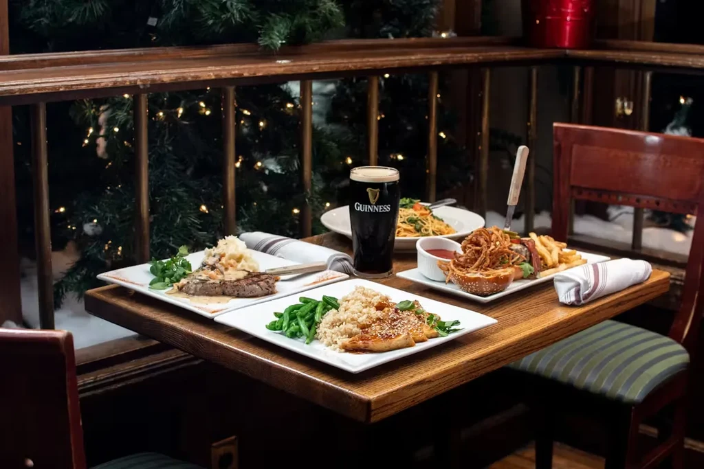 A table set with multiple dinner plates and a Guinness beer.
