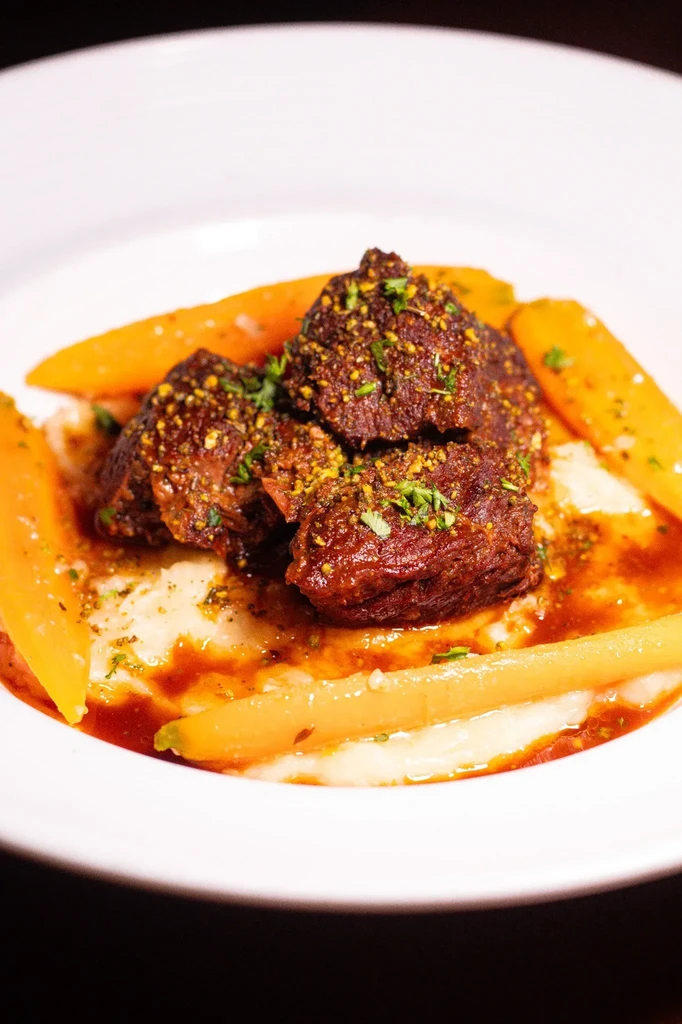 Braised beef short ribs with mashed potatoes and glazed carrots.