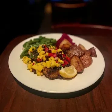 A plate of fish, mango salsa, potatoes, and green beans.