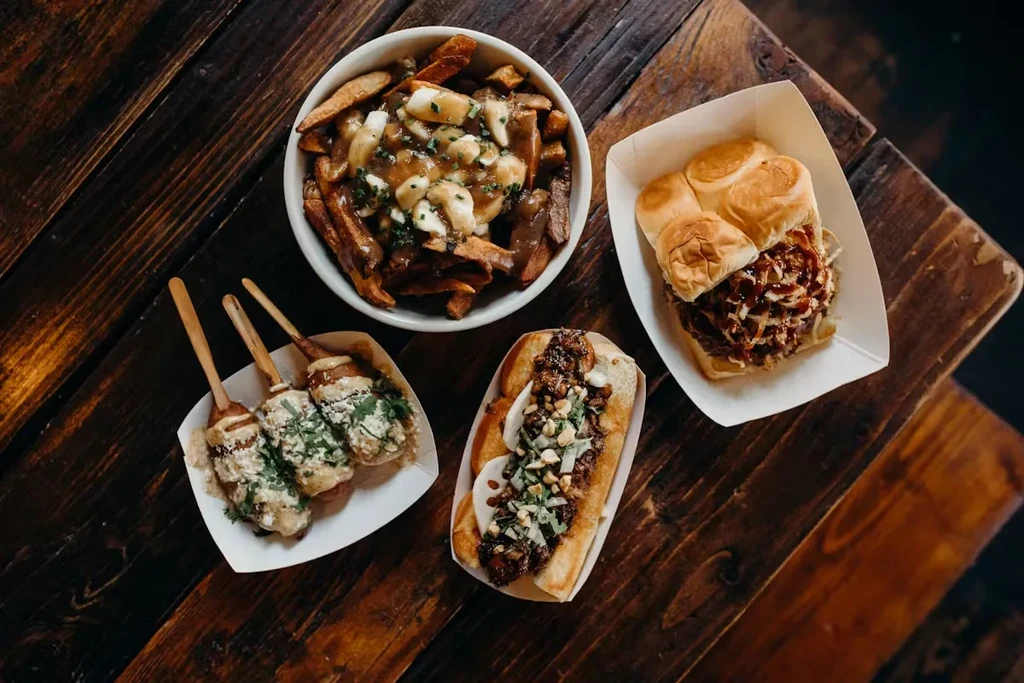 Overhead shot of poutine, hot dog, sliders, and corn dogs.