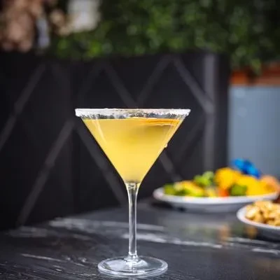 A yellow cocktail in a sugar-rimmed martini glass.