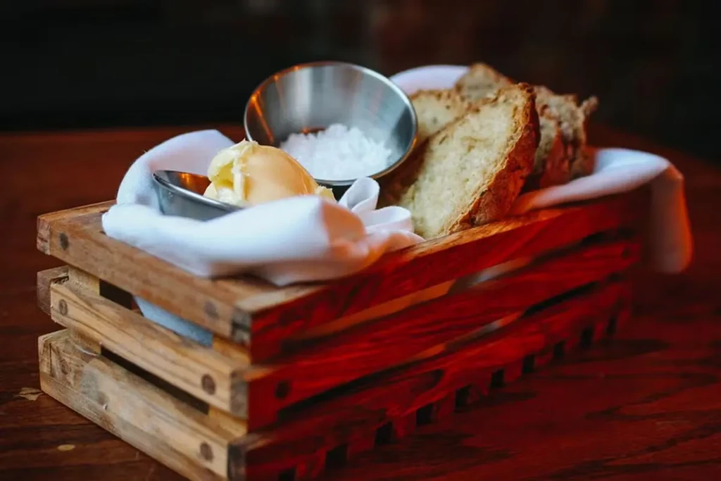 Bread slices, butter, and salt in a wooden crate.