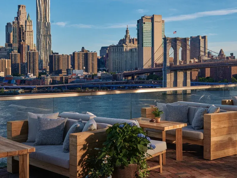 Outdoor patio overlooking NYC skyline and Brooklyn Bridge.