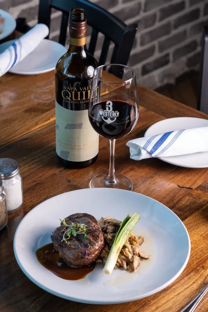 Steak, mushrooms, and scallion with a glass of red wine.