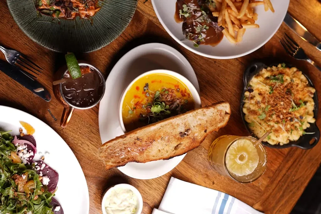 Overhead view of a wooden table laden with various dishes and drinks.