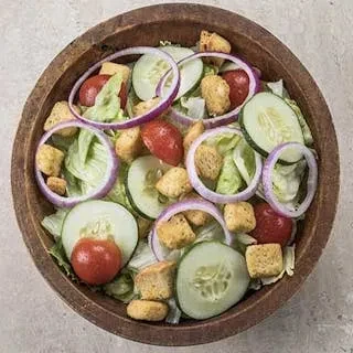 Overhead view of a salad with cucumbers, tomatoes, croutons, and lettuce.