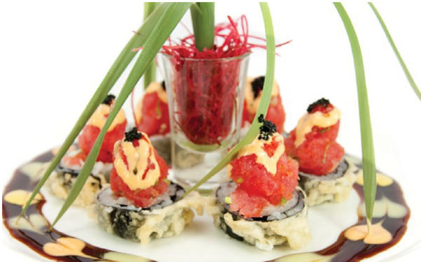 Tempura sushi rolls topped with red fish, sauce, and black roe.