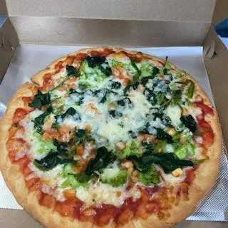 A cooked pizza with vegetables and melted cheese in a cardboard box.