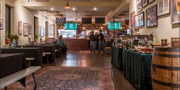 Indoor view of a restaurant with tables, a buffet, and people.