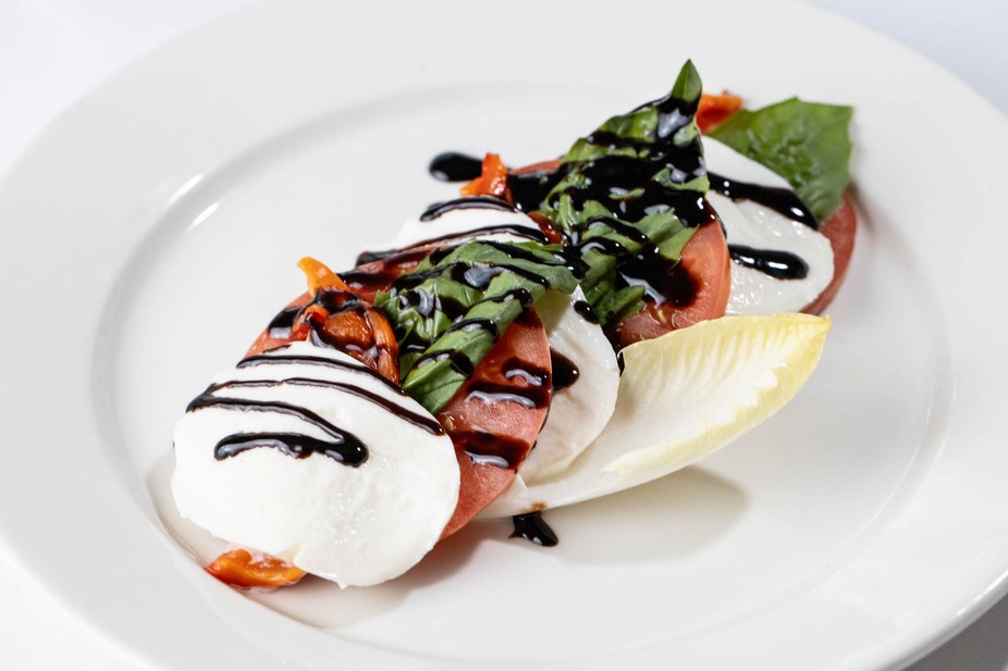 Caprese salad with mozzarella, tomatoes, basil, balsamic glaze, and endive.