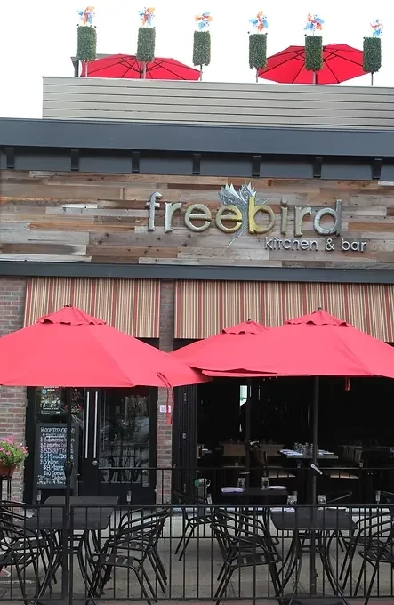 Freebird Kitchen & Bar with a street patio under red umbrellas.