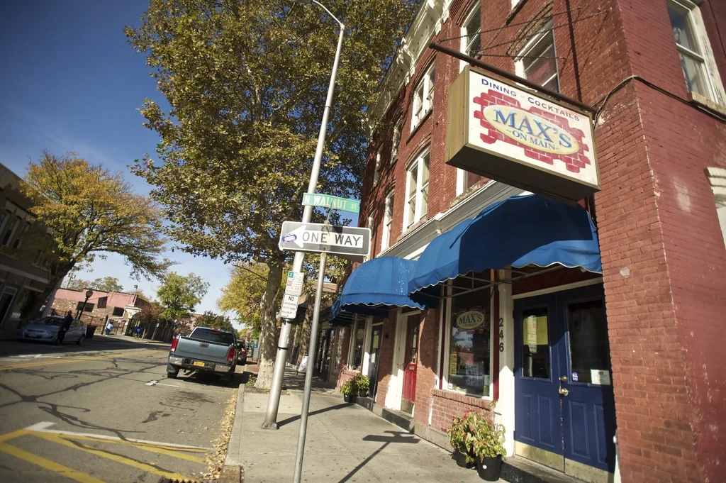 A brick building with blue awnings and a "Max's on Main" sign.