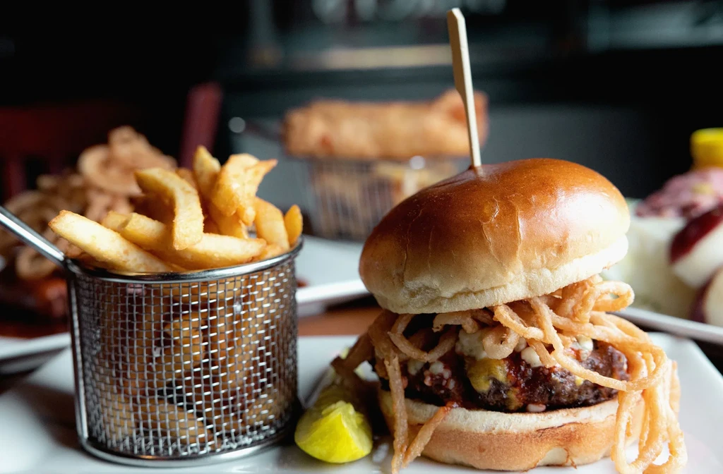 Gourmet burger with melted cheese, crispy onions, and thick-cut fries.