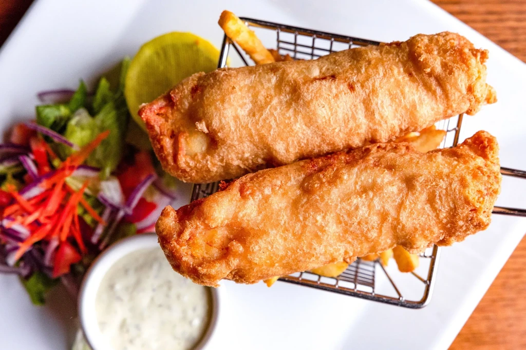 Crispy fish and chips, side salad, dipping sauce, and lemon.