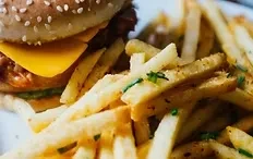 Cheeseburger and a pile of french fries with chives.