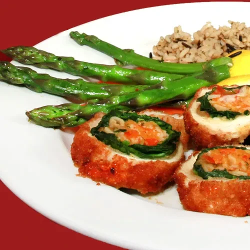Plated meal with asparagus, wild rice, lemon, and sliced protein rolls.