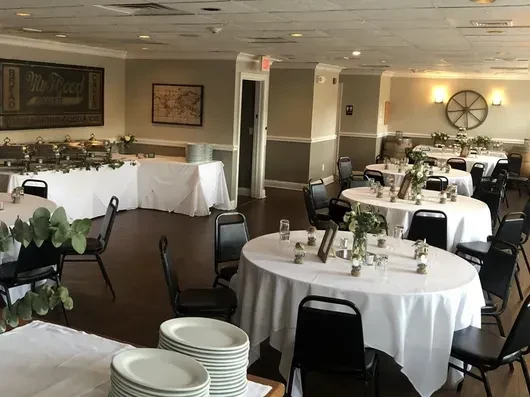 A banquet hall with buffet tables and round tables set for an event.