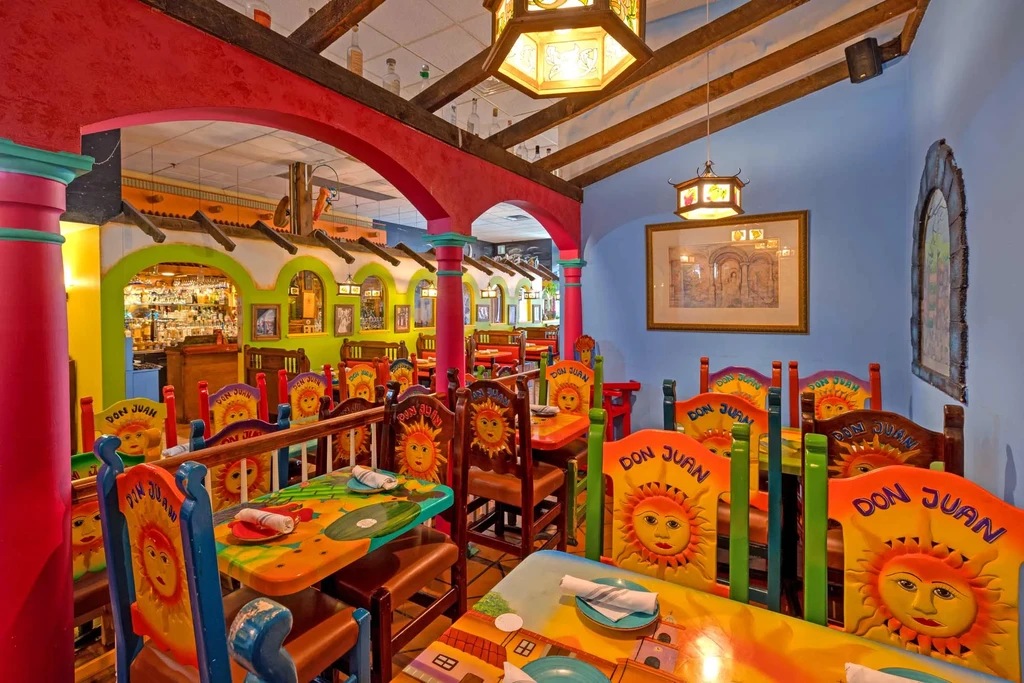 Colorful Mexican restaurant interior with Don Juan chairs and visible bar.