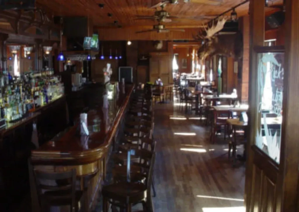 Interior of a rustic bar and restaurant with wooden furnishings.