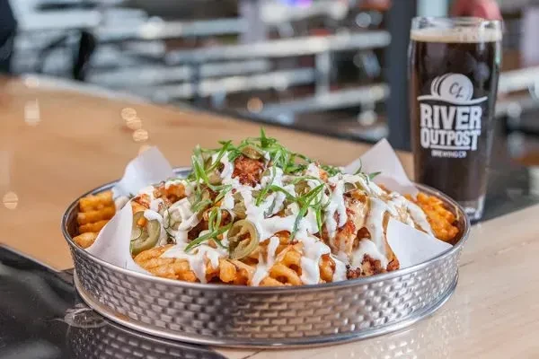 Loaded waffle fries with white sauce, jalapeños, and a dark beer.