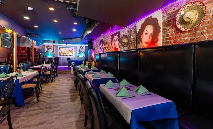 A Mexican restaurant with long tables, banquette seating, and celebrity portraits.