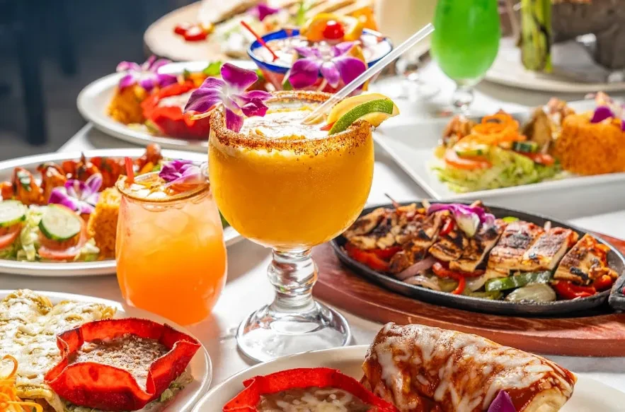 A table filled with various colorful Mexican dishes and drinks.