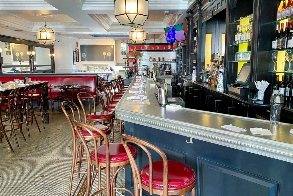 An empty bar and dining room with red leather seating.