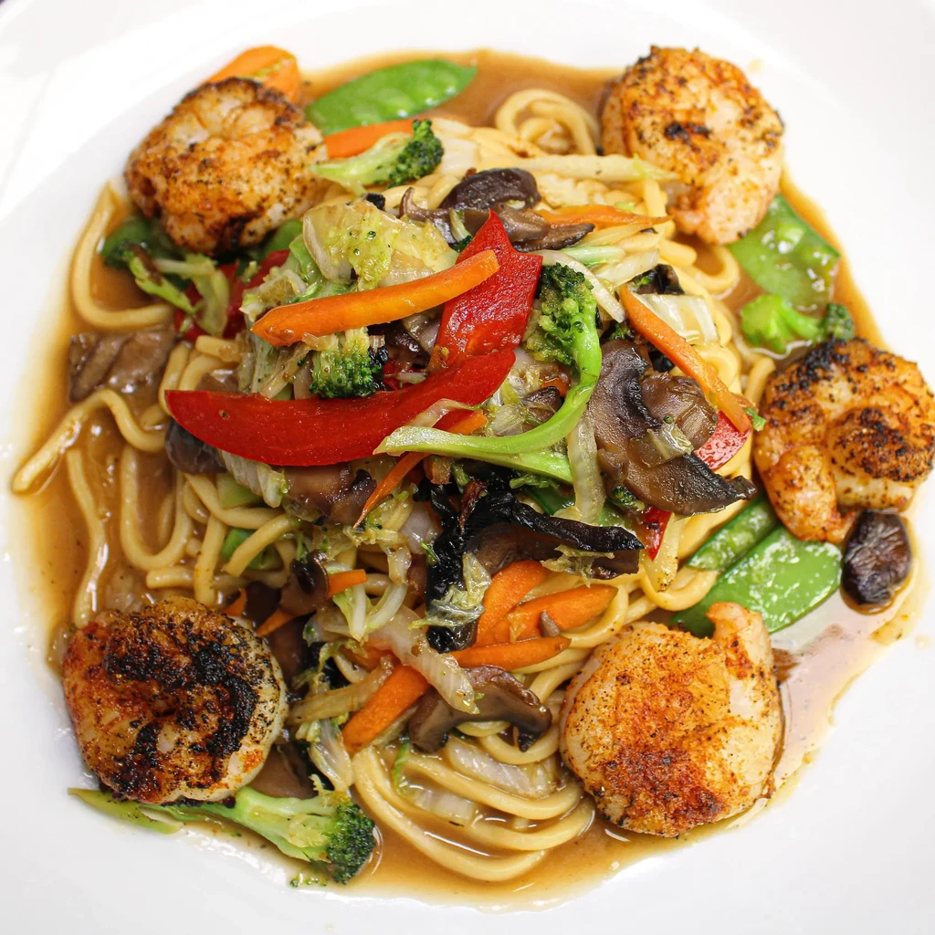 Noodle stir-fry with mixed vegetables and five seared scallops.