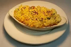 A gratin dish with golden-brown shepherd's pie on a white plate.