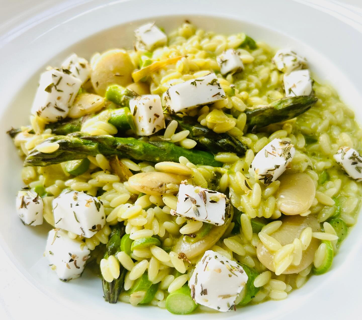 Green orzo with asparagus, white beans, and herbed cheese.