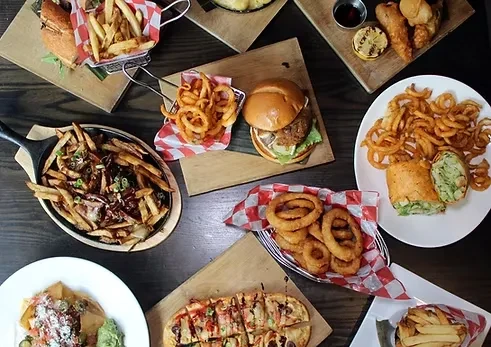 Overhead shot of many dishes, including fries, burgers, and wraps.