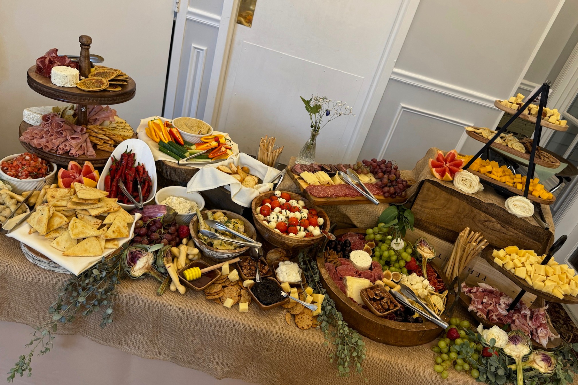 Abundant charcuterie, cheese, fruit, and vegetable grazing table.