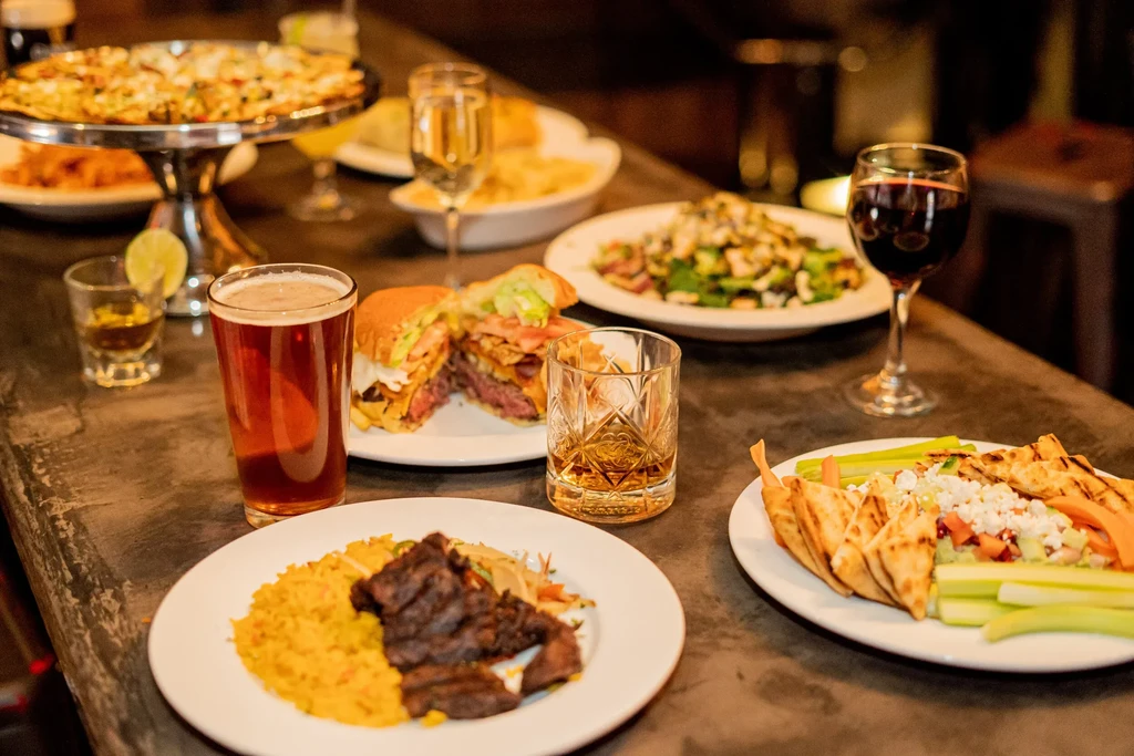 Various plates of food and drinks, including beer, wine, and a burger.