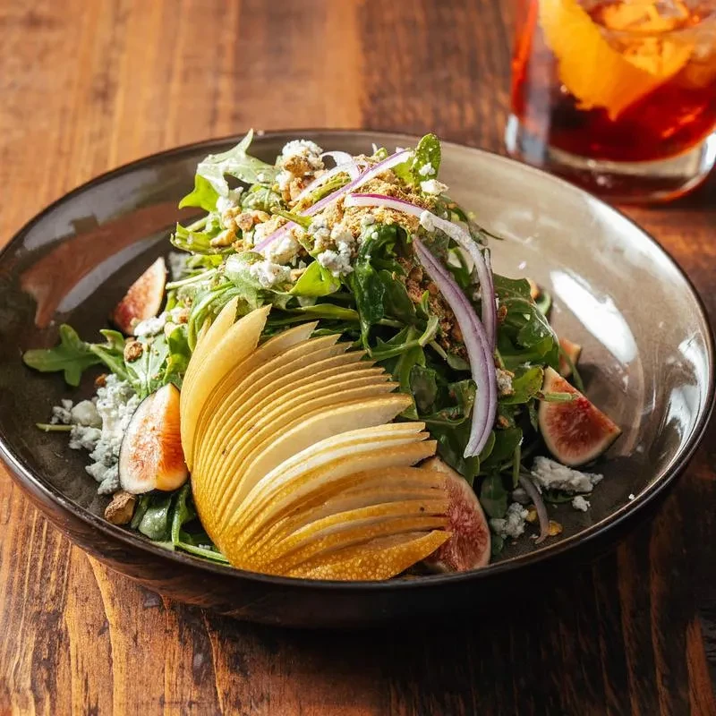 Arugula salad with figs, blue cheese, pecans, sliced pear, and red onion.