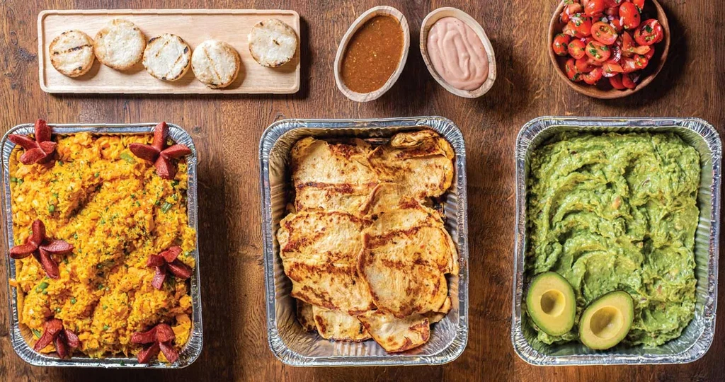 Overhead view of a meal with rice, bread, guacamole, and sauces.