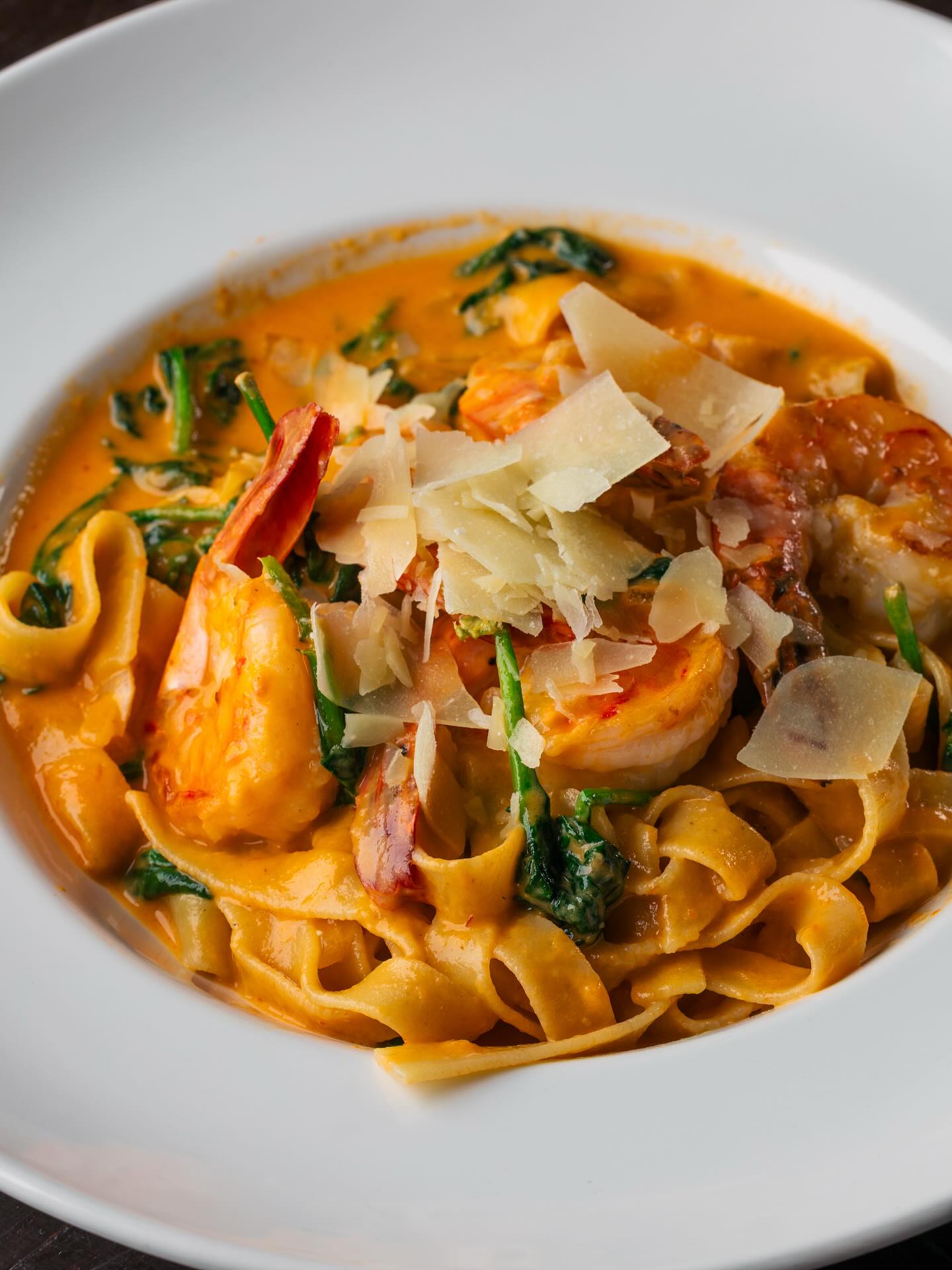 Shrimp pasta with creamy sauce, spinach, and shaved Parmesan.
