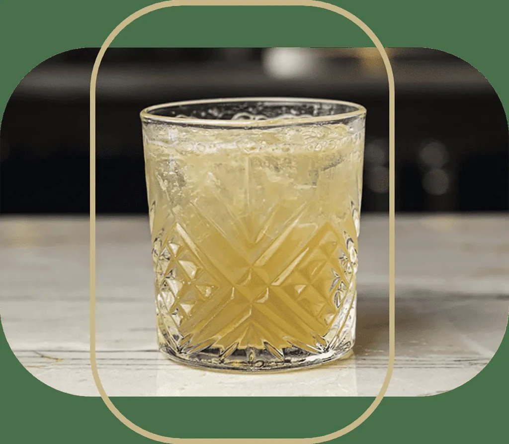 A textured glass filled with a light amber drink and ice.