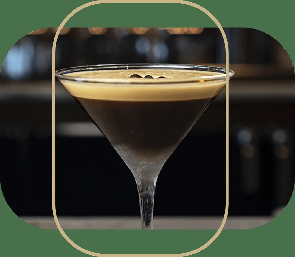 Espresso martini in a clear glass with three coffee beans.