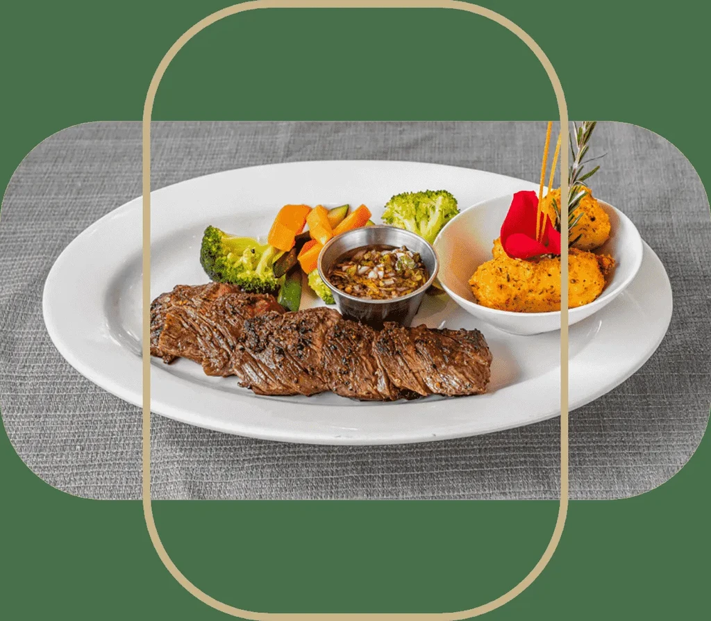 Grilled skirt steak with vegetables, dipping sauce, and side dish.