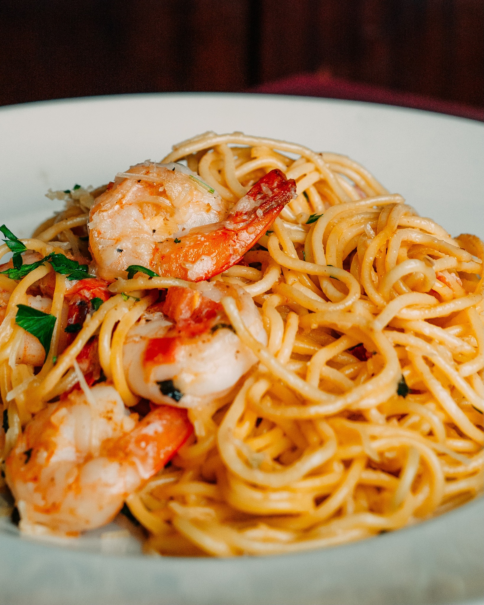 Spaghetti with shrimp, garnished with parsley and grated cheese.