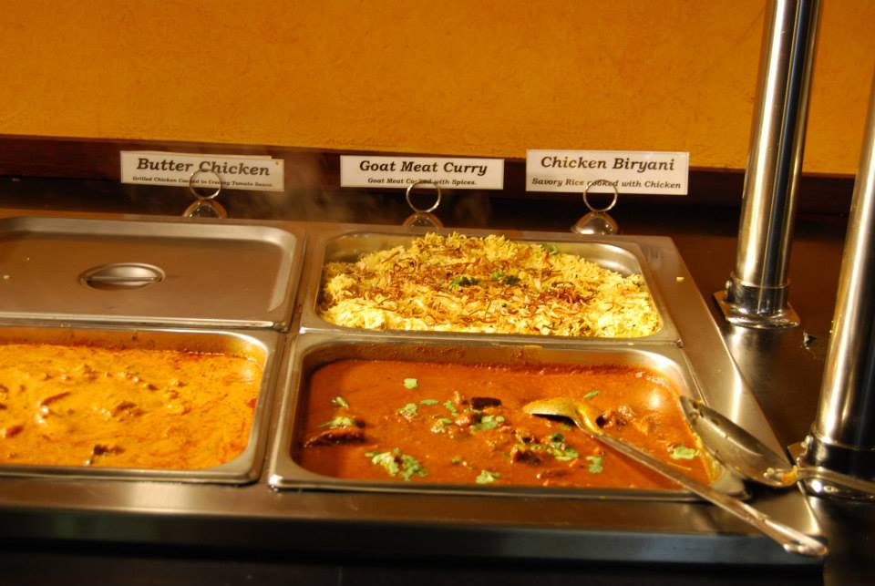 Buffet line with Butter Chicken, Goat Meat Curry, and Chicken Biryani.