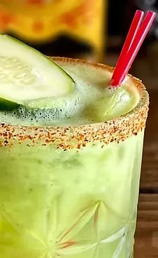 A green cocktail with cucumber and a chili-lime rim.