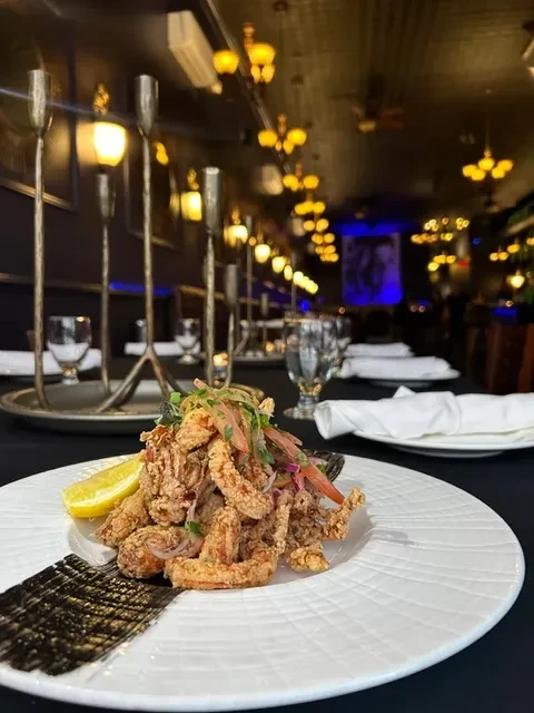 Fried shrimp with lemon on a white plate in a restaurant.