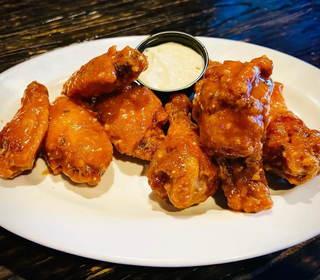 Plate of buffalo wings with dipping sauce.