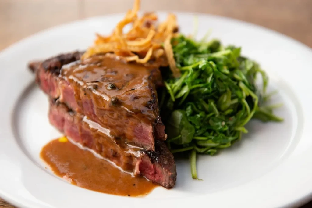 Steak with gravy, crispy onions, and a side of green salad.