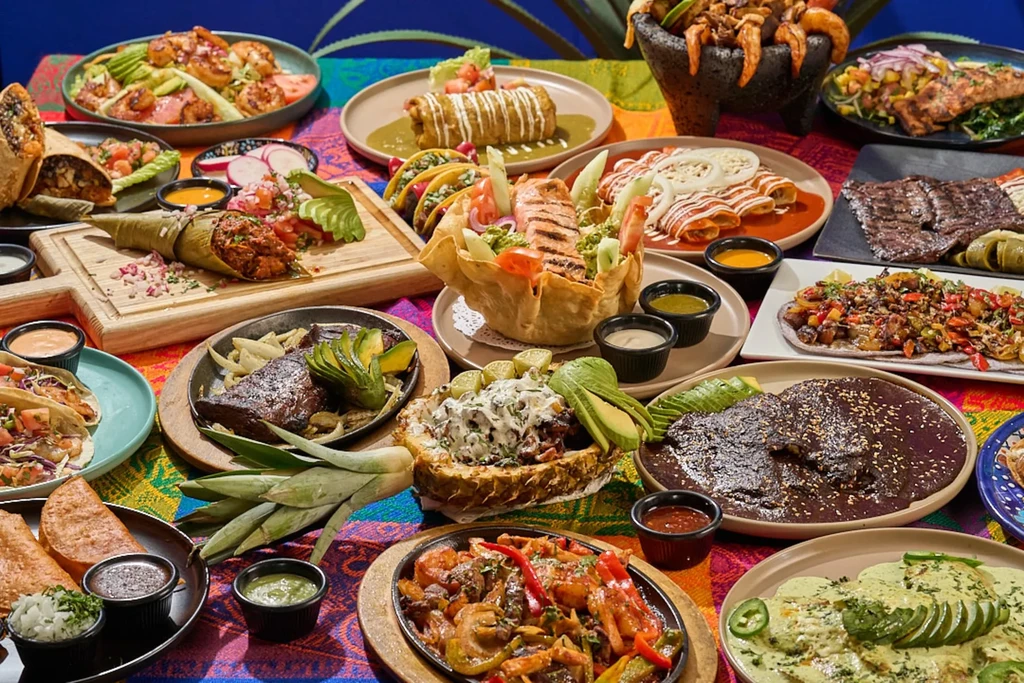 An overhead shot of a table covered with a large array of Mexican dishes.
