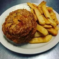 A fried crabcake with a side of french fries and coleslaw.