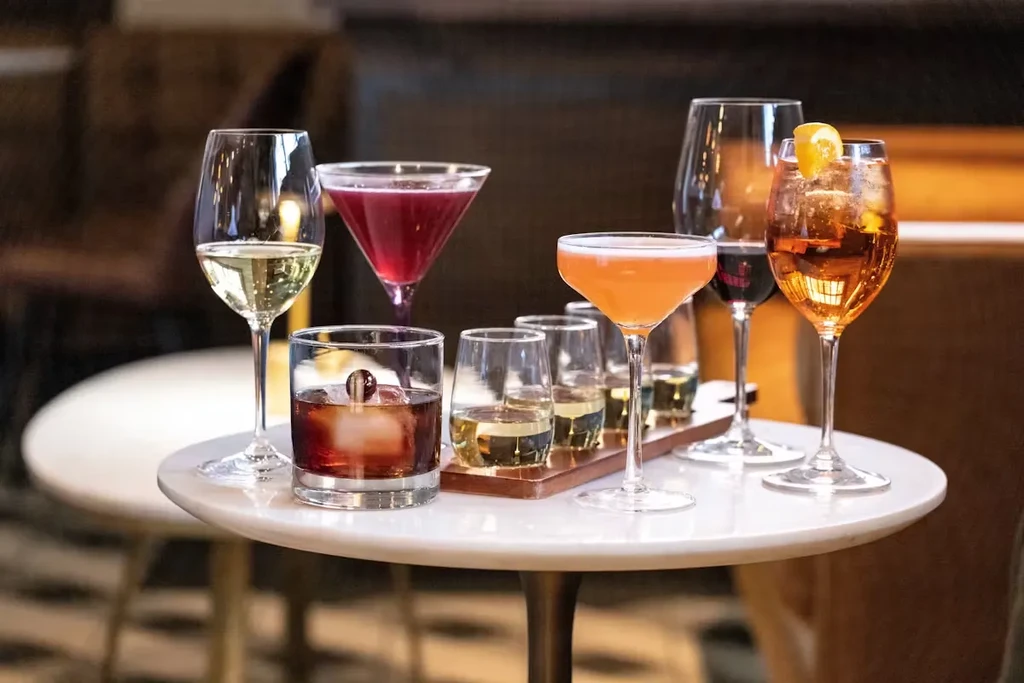 A white marble table with various colorful cocktails and drinks.