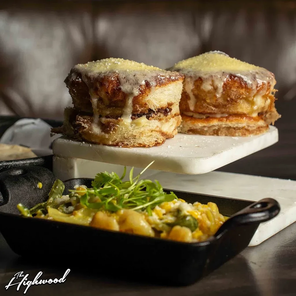 Two sweet buns with icing on a stand, and mac and cheese below.
